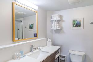 Baño blanco con lavabo y espejo en Hampton Inn La Crosse/Onalaska, en Onalaska