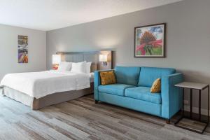Hampton Inn La Crosse/Onalaska في Onalaska: غرفة نوم بسرير واريكة زرقاء