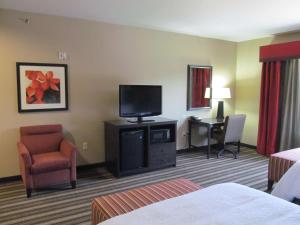 Habitación de hotel con TV, silla y escritorio. en Hampton Inn and Suites Hope en Hope