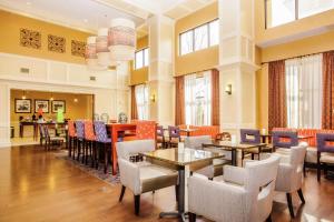 un comedor con mesas, sillas y ventanas en Hampton Inn & Suites Sevierville at Stadium Drive, en Kodak