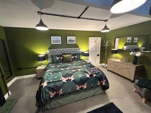 een slaapkamer met een bed en groene muren bij The Green House Hythe in Kent