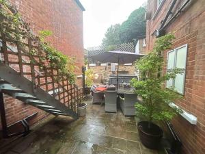 an outdoor patio with a table and an umbrella at The Green House Hythe in Kent