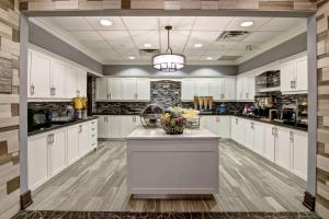 a large kitchen with white cabinets and a island at Homewood Suites by Hilton Burlington in Burlington