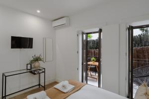 een witte slaapkamer met een bed en een balkon bij Downtown Terrace Flat with AC and Patio - feel like a local in Porto