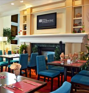 un ristorante con tavoli, sedie e un camino di Hilton Garden Inn Philadelphia Center City a Philadelphia