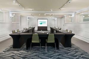 a conference room with a table and chairs and a screen at Homewood Suites by Hilton Raleigh-Durham Airport at RTP in Durham