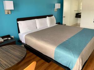 a bedroom with a large bed with a blue wall at Motel 6 Pismo Beach CA Pacific Ocean in Pismo Beach