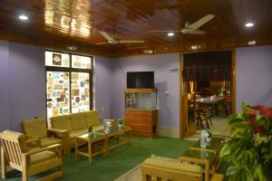 a living room with chairs and a table and a fish tank at Besham Hilton Hotel, by LMC 