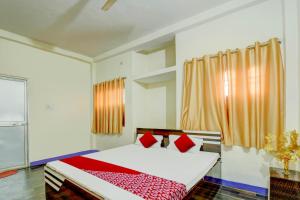 a bedroom with a bed with red and white at OYO Flagship Hotel Shubhmangalam in Patna