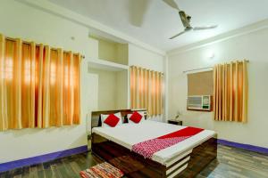 um quarto com uma cama com almofadas vermelhas em OYO Flagship Hotel Shubhmangalam em Patna