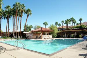 uma grande piscina com palmeiras num resort em Hilton Garden Inn Palm Springs/Rancho Mirage em Rancho Mirage