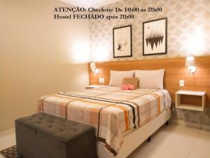 1 dormitorio con 1 cama con reposapiés al lado en Elô Hostel en Brasilia
