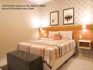 1 dormitorio con 1 cama con reposapiés en Elô Hostel en Brasilia
