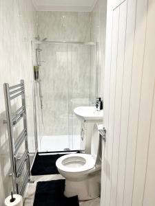 a bathroom with a shower and a toilet and a sink at Convenient & Modern Private Bedroom Space near Barnsley Hospital in Barnsley