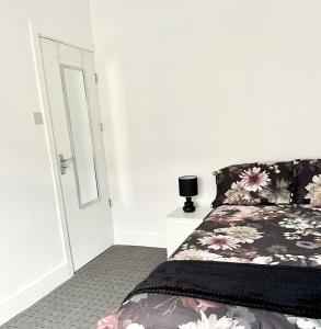 Schlafzimmer mit einem Bett mit einem Kissen mit Blumenmuster in der Unterkunft Convenient & Modern Private Bedroom Space near Barnsley Hospital in Barnsley