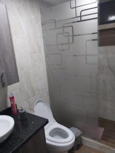 y baño con aseo blanco y lavamanos. en Departamento moderno y amoblado, en Quito