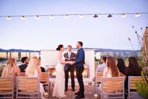 eine Braut und ein Bräutigam-Austauschgelübde bei ihrer Hochzeitszeremonie in der Unterkunft Hilton Garden Inn Santa Barbara/Goleta in Santa Barbara