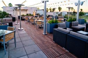 a restaurant with tables and chairs on a patio at Hilton Garden Inn Santa Barbara/Goleta in Santa Barbara