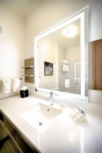 uma casa de banho com um lavatório e um espelho grande em Hilton Garden Inn Santa Barbara/Goleta em Santa Bárbara