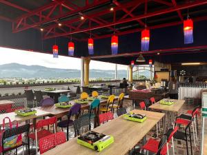 埔里鎮的住宿－華秝茶油幸福莊園，餐厅设有木桌和五颜六色的椅子