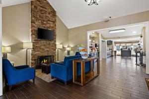 sala de estar con 2 sillas azules y chimenea en Comfort Inn Wytheville en Wytheville