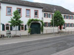 Hotel Stadt Mainz في Schwabenheim: مبنى أبيض مع باب أخضر على شارع