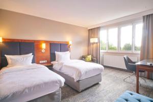 una camera d'albergo con 2 letti e una scrivania di Radisson Blu Hotel Dortmund a Dortmund