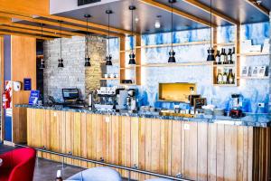 a restaurant with a counter with a coffee shop at Hampton By Hilton Bariloche in San Carlos de Bariloche