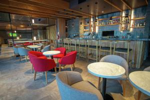 um restaurante com mesas e cadeiras e um bar em Hampton By Hilton Bariloche em San Carlos de Bariloche