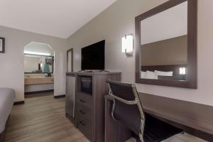 a hotel room with a bed and a television at Quality Inn Charleston - West Ashley in Charleston