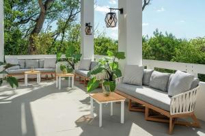 une terrasse avec des canapés, des tables et des plantes dans l'établissement Baker's Cay Resort Key Largo, Curio Collection By Hilton, à Key Largo