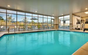 - une grande piscine d'eau bleue dans un bâtiment dans l'établissement Hilton Garden Inn Lehi, à Lehi