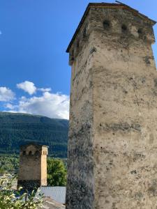 una vecchia torre di pietra e un edificio su un tetto di Lam Lha a Mestia