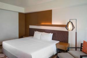 1 dormitorio con 1 cama blanca grande y 1 silla en Radisson Blu Cebu, en Cebú