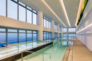 a swimming pool in a building with windows at Doubletree by Hilton Foshan Nanhai-Free Canton Fair Shuttle Bus in Foshan