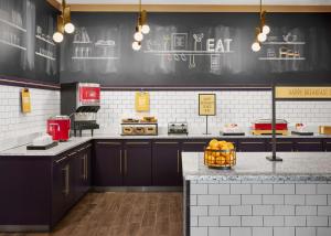 a kitchen with black cabinets and a counter with a basket of oranges at Hampton Inn & Suites Charlotte Steele Creek Road, NC in Charlotte