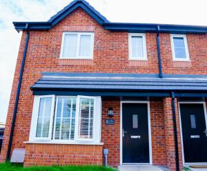 a red brick house with a black door at Caasi Homes in Leigh