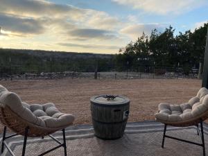 two chairs and a barrel on a patio at Airstream Alfresco in Fredericksburg