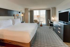 a hotel room with a bed and a flat screen tv at The Chattanoogan Hotel, Curio Collection By Hilton in Chattanooga