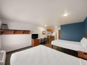 Camera con letto e scrivania con TV di WoodSpring Suites Dallas Rockwall a Rockwall