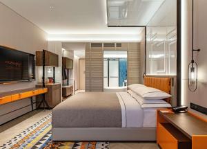 1 dormitorio con 1 cama grande y TV en Canopy by Hilton Hangzhou West Lake en Hangzhou