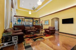 sala de estar con muebles de cuero y TV de pantalla plana en Quality Inn & Suites, en Houston