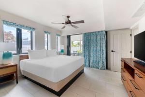 a white bedroom with a large bed and windows at Hilton Vacation Club Royal Palm St Maarten in Simpson Bay