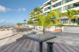 a bench on the beach next to a building at Hilton Vacation Club Royal Palm St Maarten in Simpson Bay