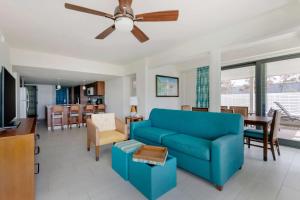 a living room with a blue couch and a dining room at Hilton Vacation Club Royal Palm St Maarten in Simpson Bay