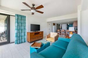a living room with a blue couch and a tv at Hilton Vacation Club Royal Palm St Maarten in Simpson Bay