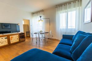 SkyAttic - 801 - CItyLife - 1 min Domodossola M5 في ميلانو: غرفة معيشة مع أريكة زرقاء وطاولة