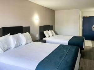 a hotel room with two beds with white sheets at Studio 6 Suites Delano, CA in Delano +20 photos
