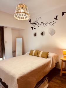 1 dormitorio con 1 cama con pájaros en la pared en Departamento Categoria Centro By Lofter en La Plata