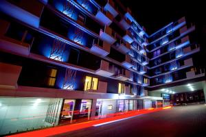 un edificio de noche con luces azules y rojas en Rest Apartments, en Wroclaw